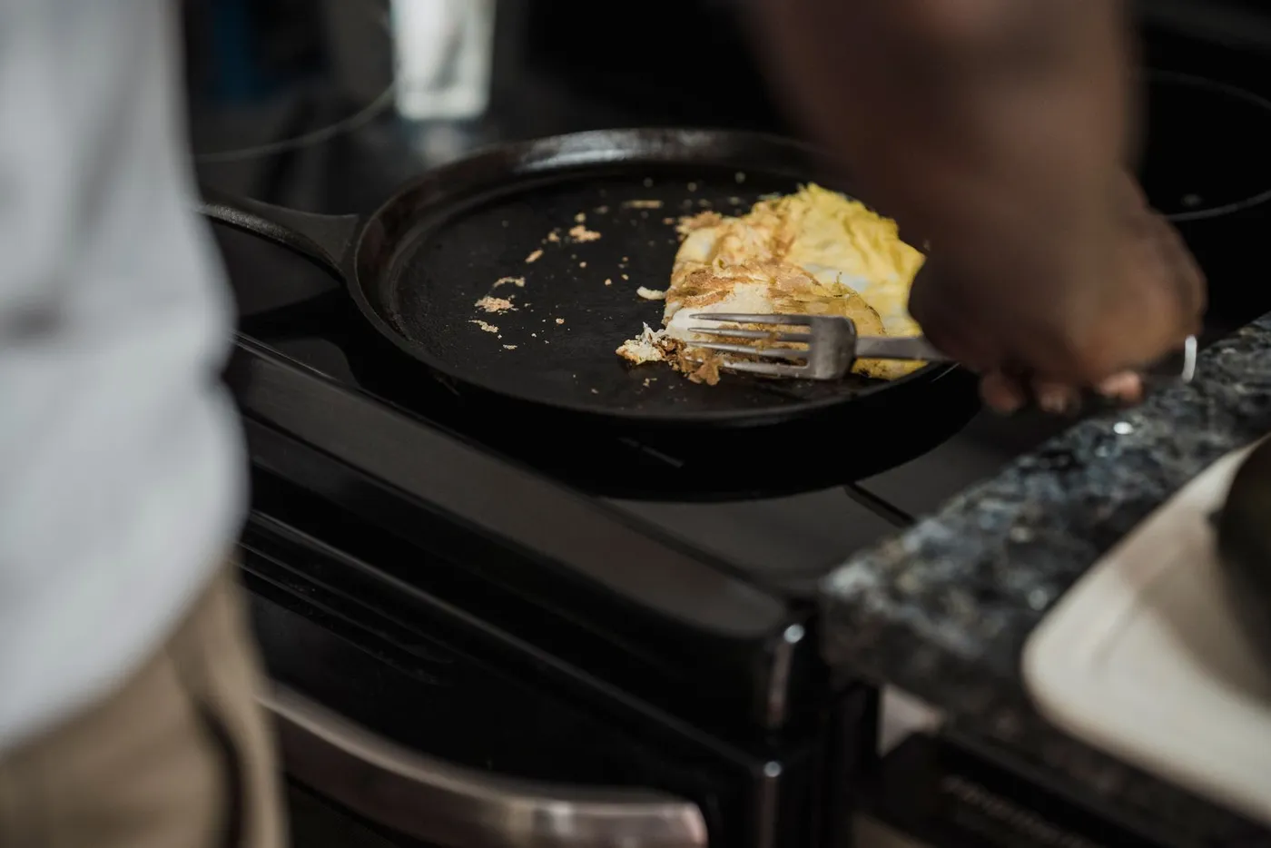 Home cook making an omelet in a pan on the stove